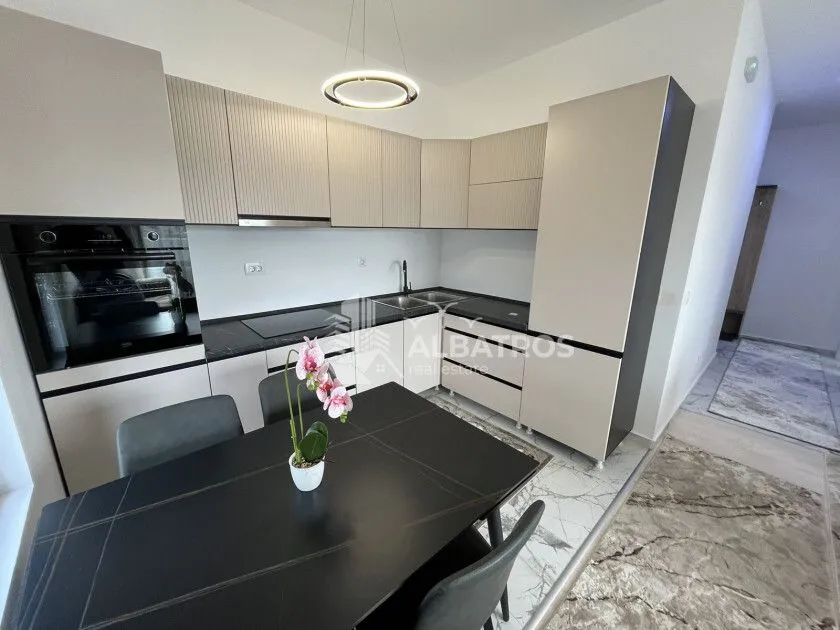 Modern kitchen with built-in appliances and a dining table.