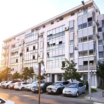 Exterior view of an apartment building with parking in front. - image 9