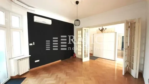 Spacious living room with parquet flooring and a black accent wall. - image 2