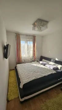 Bedroom with a double bed, window, and wall-mounted TV. - image 9