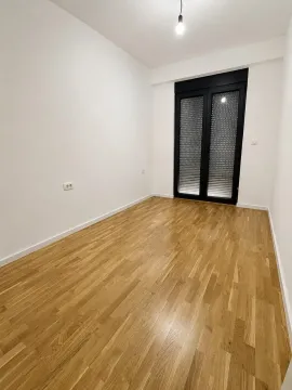 Prazna soba sa parketom i balkonskim vratima. - image 3