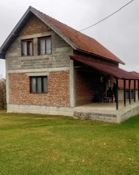 Eksterijer kuće sa pokrivenom terasom i travnjakom u dvorištu. - image 16