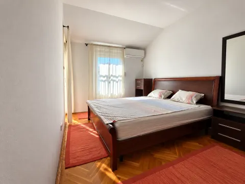 Spavaća soba sa bračnim krevetom, drvenim parketom i prozorom sa svjetlosnim zavjesama. - image 10
