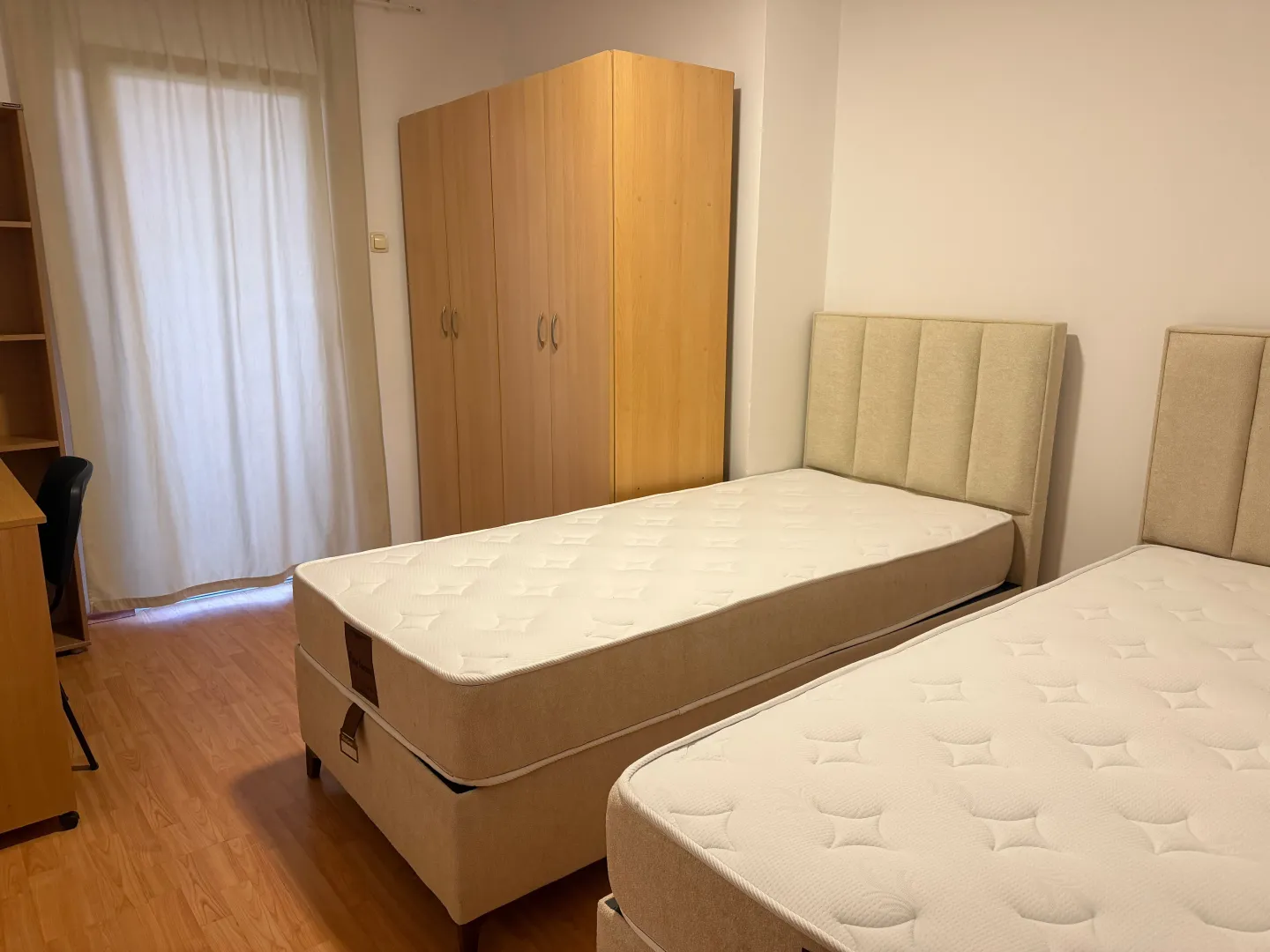 Bedroom with two single beds, a wardrobe and a desk.