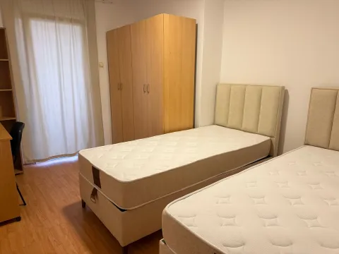 Bedroom with two single beds, a wardrobe and a desk. - image 5