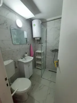 Manje kupatilo sa tuš kabinom, umivaonikom i wc šoljom obloženo mermernim pločicama. - image 13
