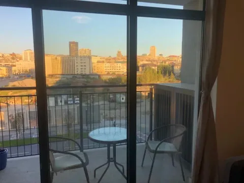 Furnished balcony with a table, chairs, and city view. - image 4