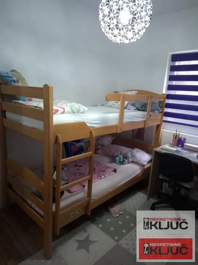 Dečja soba sa krevetom na sprat i radnim stolom.