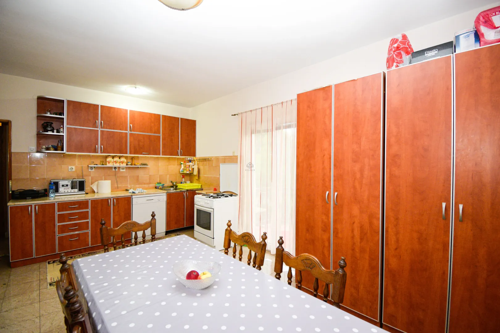 Kitchen with dining area and wooden cabinets.