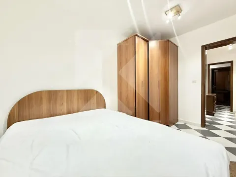 Bedroom with a double bed and a wooden wardrobe. - image 8