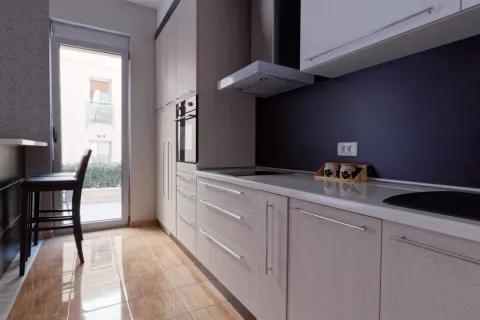 Modern kitchen with light cabinetry and a dining area. - image 9