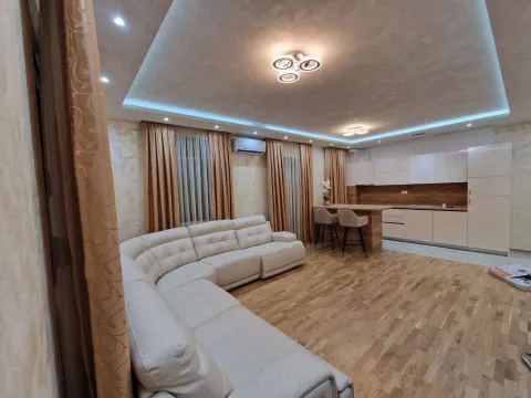 Bright living room featuring a spacious corner sofa and a kitchen in the background. - image 4