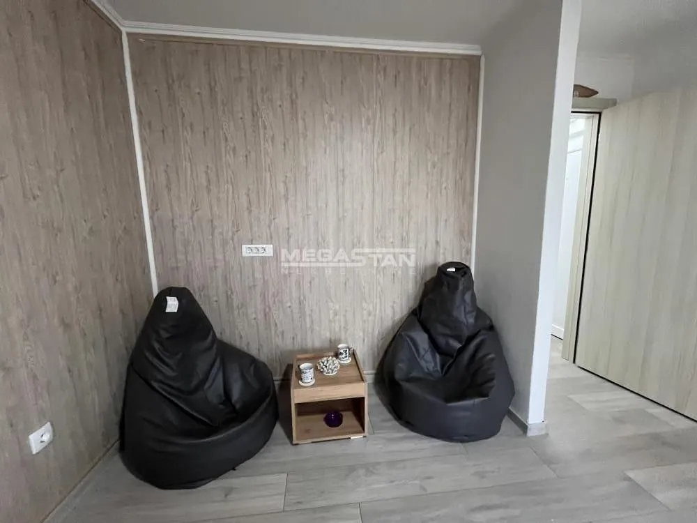 Manja dnevna soba sa dve fotelje vreće i stočićem.