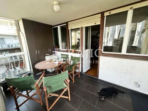 Covered balcony with a table, chairs, and a cabinet. - image 7