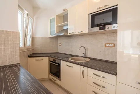 Bright and equipped kitchen with built-in appliances and a sink. - image 12