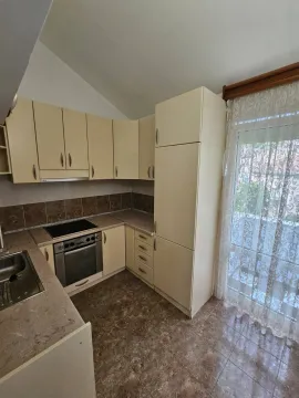 Kuhinja opremljena elementima u svijetlim tonovima i ugradnim uređajima. - image 4