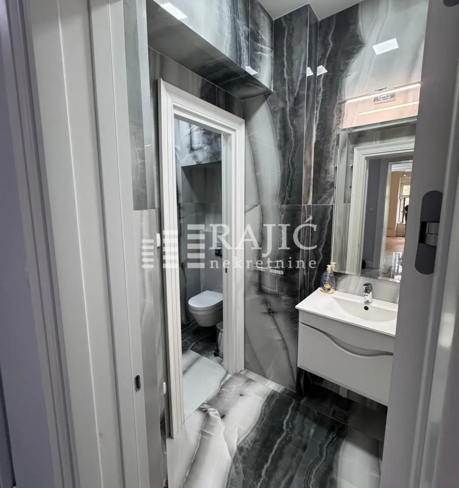 Modern bathroom with a sink and black and white marble tiles.