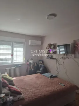 Nameštena spavaća soba sa bračnim krevetom, klima-uređajem i televizorom na zidu. - image 7