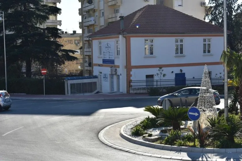 Pogled na spoljašnjost zgrade i okolnu ulicu sa kružnim tokom.