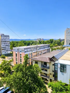 Pogled iz stana na okolne zgrade i zelenilo. - image 8