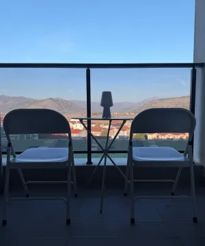 Furnished terrace with a table, two chairs, and a view of the surroundings. - image 14