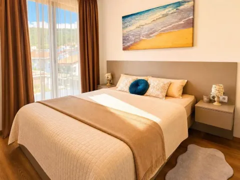 Comfortable bedroom with a large double bed, bedside tables, and balcony doors. - image 7