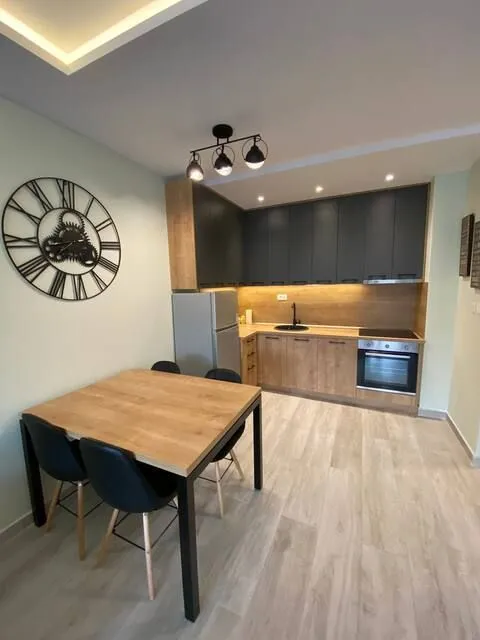 Modern kitchen with a dining table and dark cabinetry.