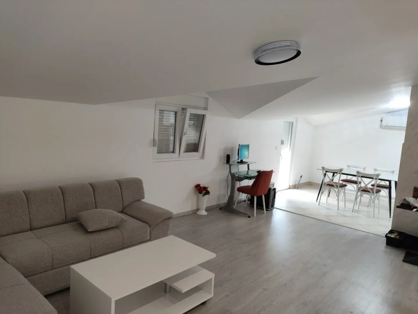 Bright living room featuring a sofa, coffee table, and dining area.