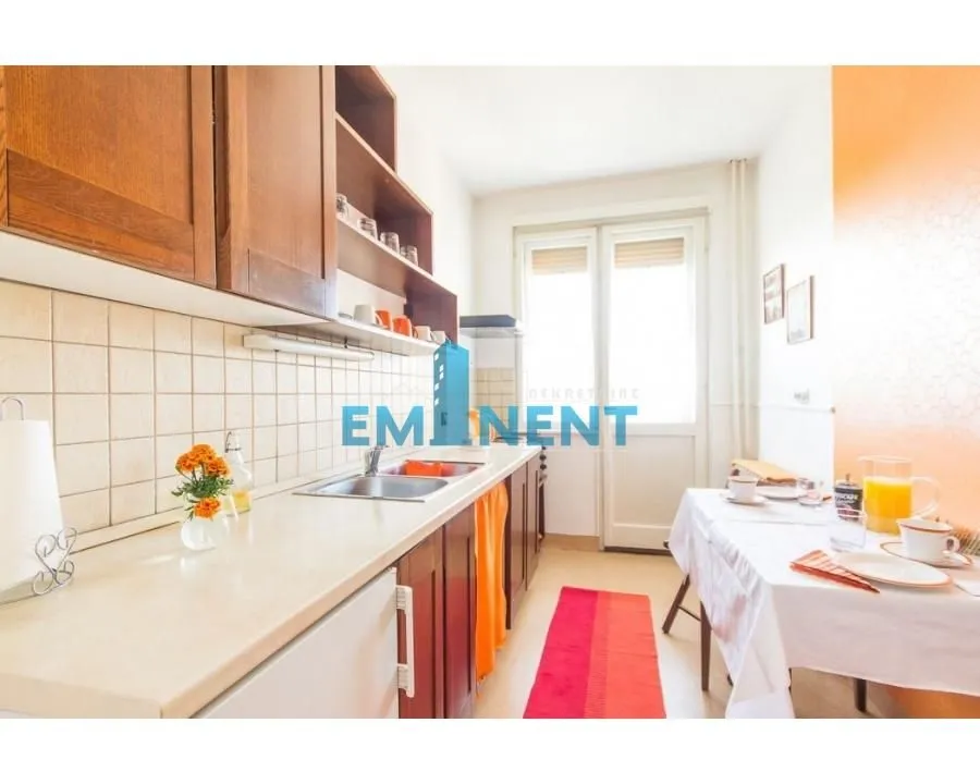 Smaller kitchen with wooden cabinets and a dining table.