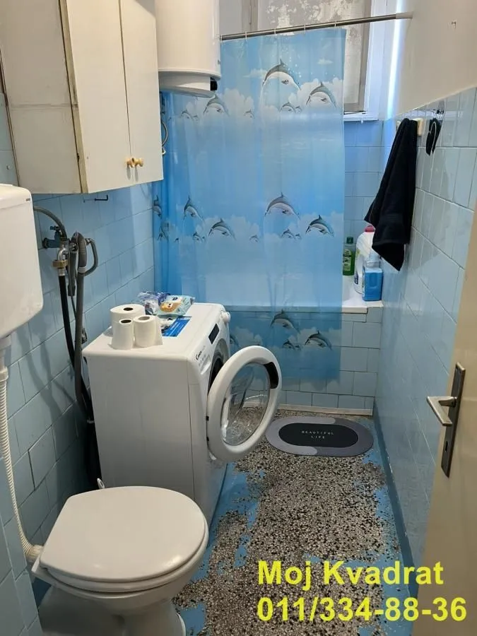 Kupatilo sa toaletom, veš mašinom i kadom.