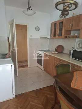 Kitchen with wooden cabinets and a dining table. - image 2