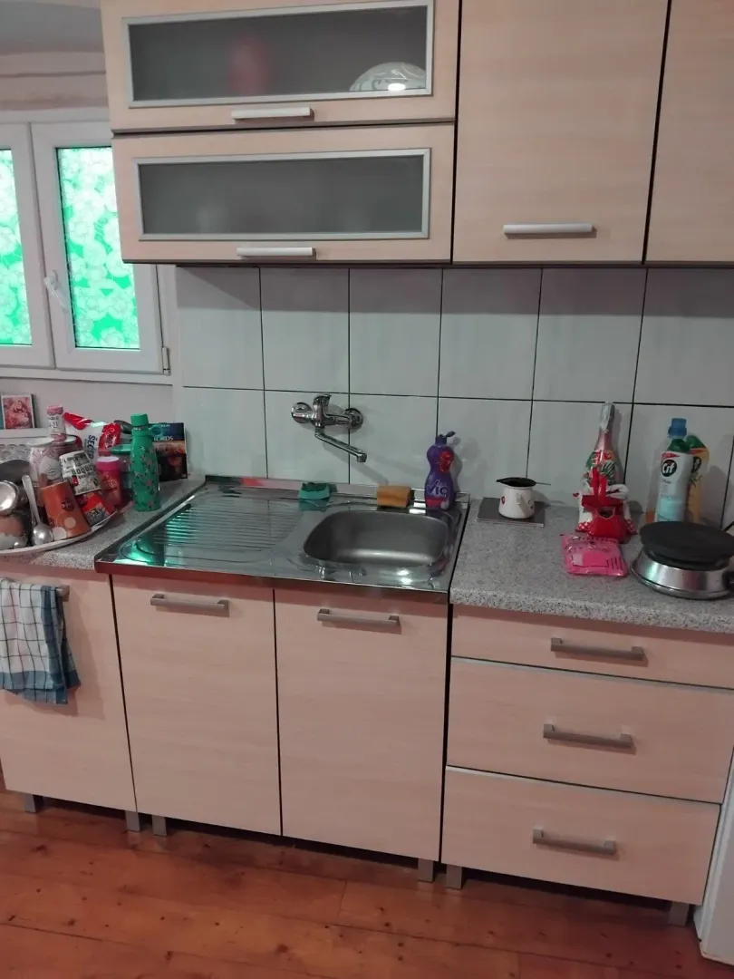 Manja kuhinja sa svijetlim elementima i sudoperom.
