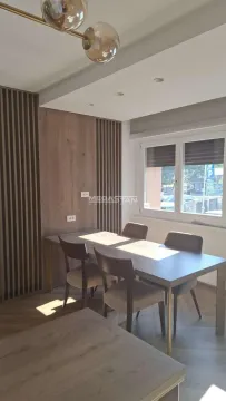 Dining area with a table and chairs by the window. - image 6