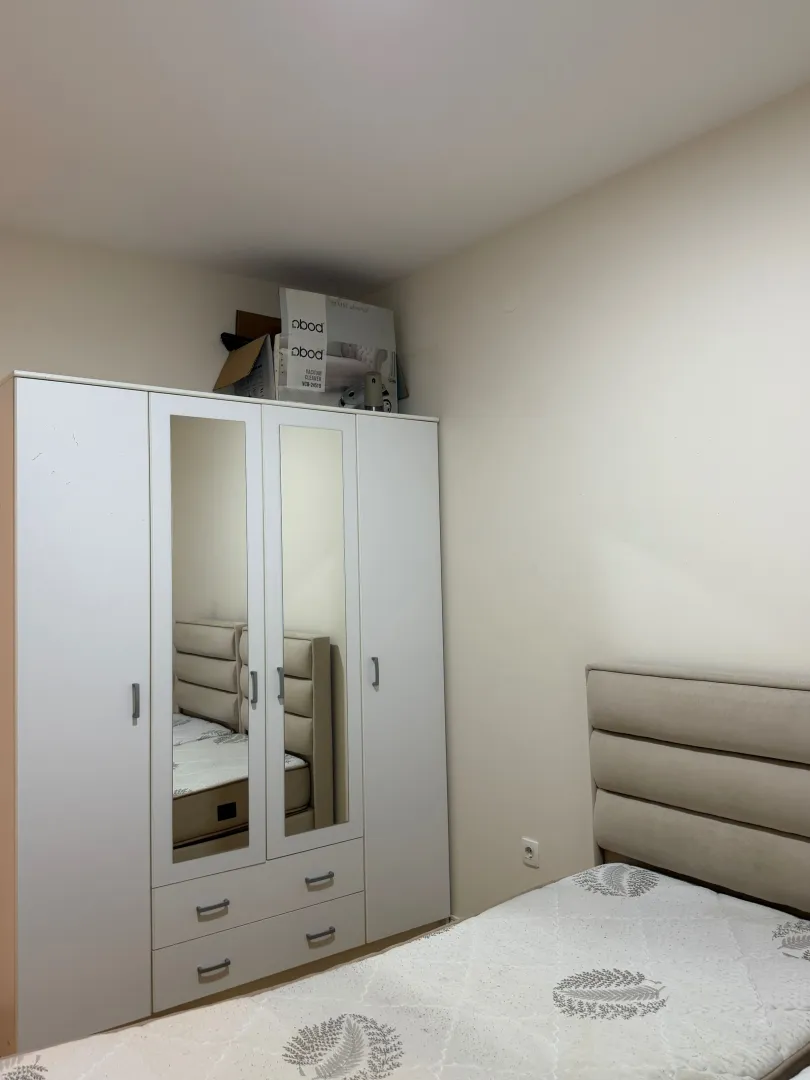 Furnished bedroom with a wardrobe and bed.