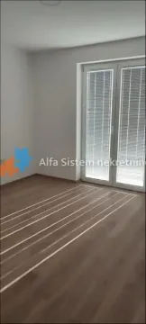 Empty room with laminate flooring and balcony doors. - image 5