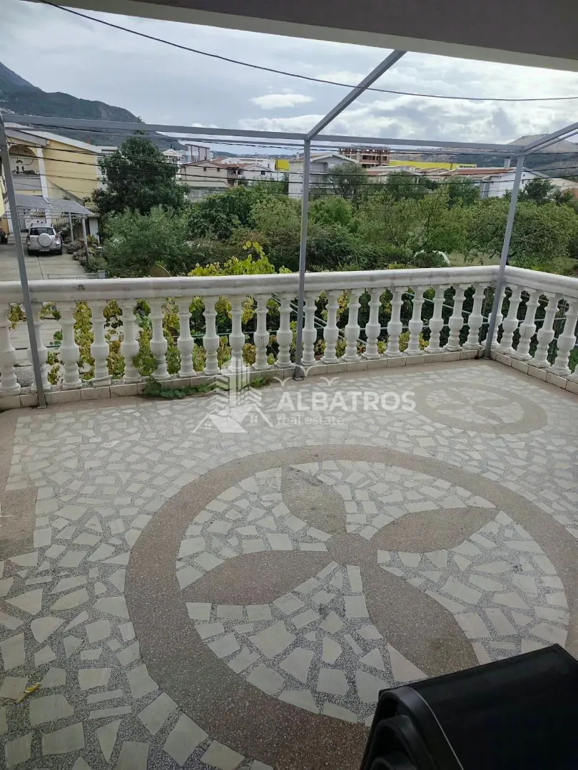 Prostrana terasa sa kamenim mozaikom na podu i pogledom na dvorište i okolinu.