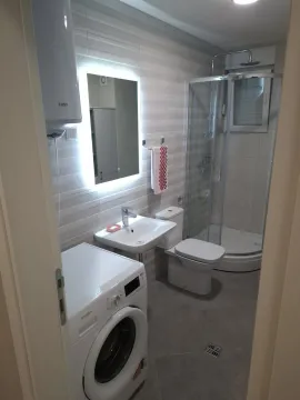Savremeno opremljeno kupatilo sa tuš kabinom, umivaonikom, toaletom i mašinom za veš. - image 11