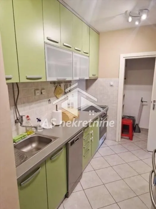 Kitchen equipped with green cabinetry and basic home appliances.