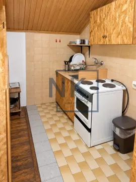 Manja kuhinja sa šporetom, radnim elementima i drvenom oblogom na zidovima i plafonu. - image 8