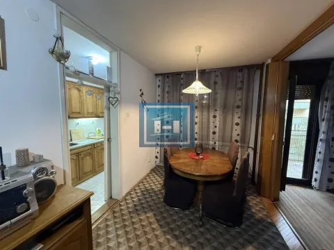 Dining area with a wooden table and chairs, with a view of the kitchen and access to the terrace. - image 3