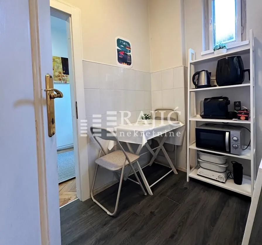 Small kitchen with a dining table and white appliance shelf.