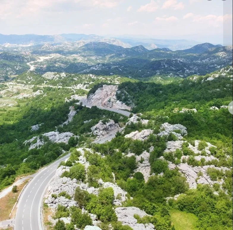 Panoramski pogled na planinski pejzaž i vijugavi put.