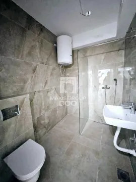Kupatilo obloženo keramičkim pločicama sa tuš kabinom, umivaonikom i wc šoljom. - image 9