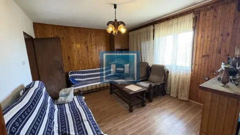 Dnevna soba obložena drvetom sa garniturom za sedenje i prozorom. - image 2