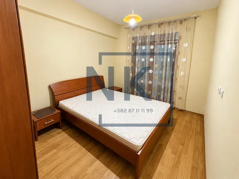 Furnished bedroom with a double bed, bedside tables and a wardrobe.