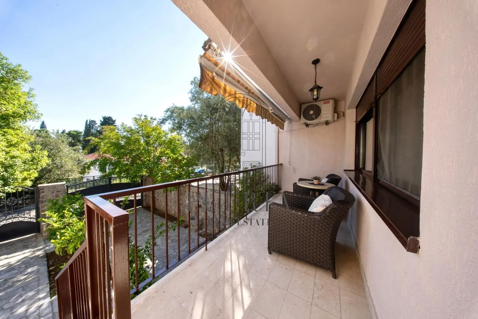 Spacious terrace with seating furniture and a view of the yard.
