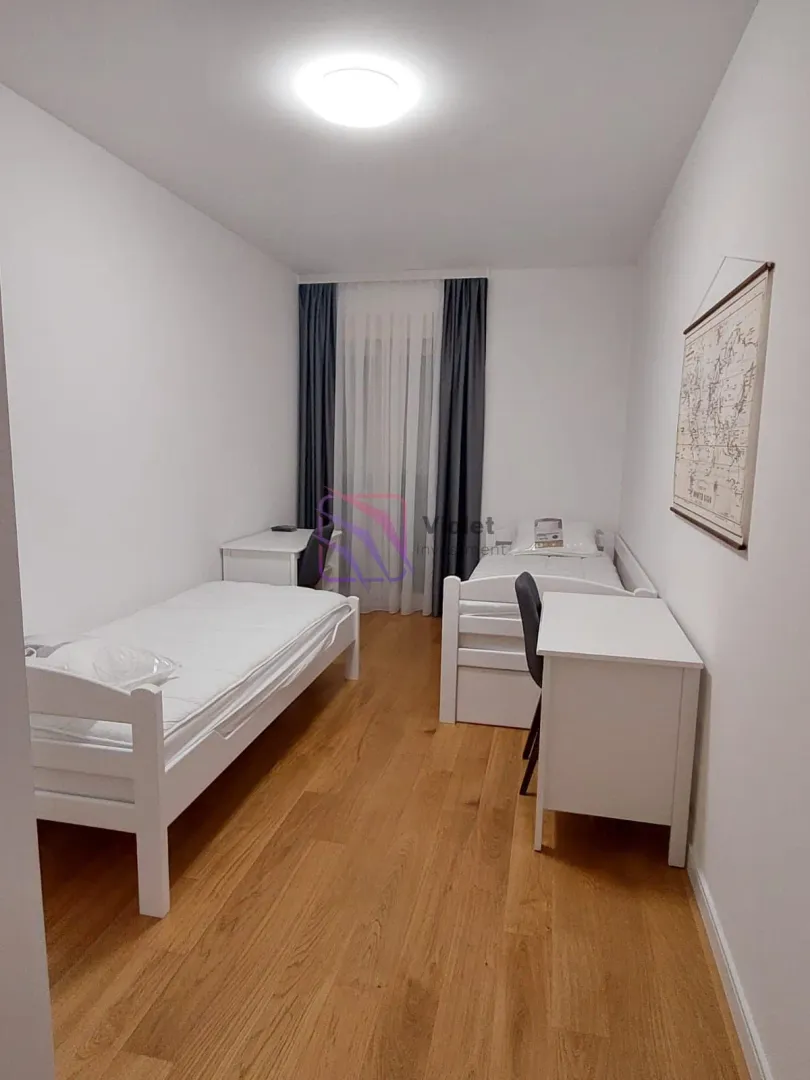 Bedroom with two beds and a desk.