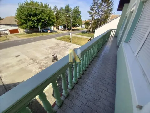 Dugačka popločana terasa sa zelenom ogradom i pogledom na ulicu. - image 35