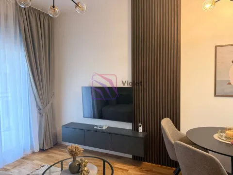 Dnevna soba sa TV-om, trpezarijskim stolom i drvenim zidnim panelima. - image 4