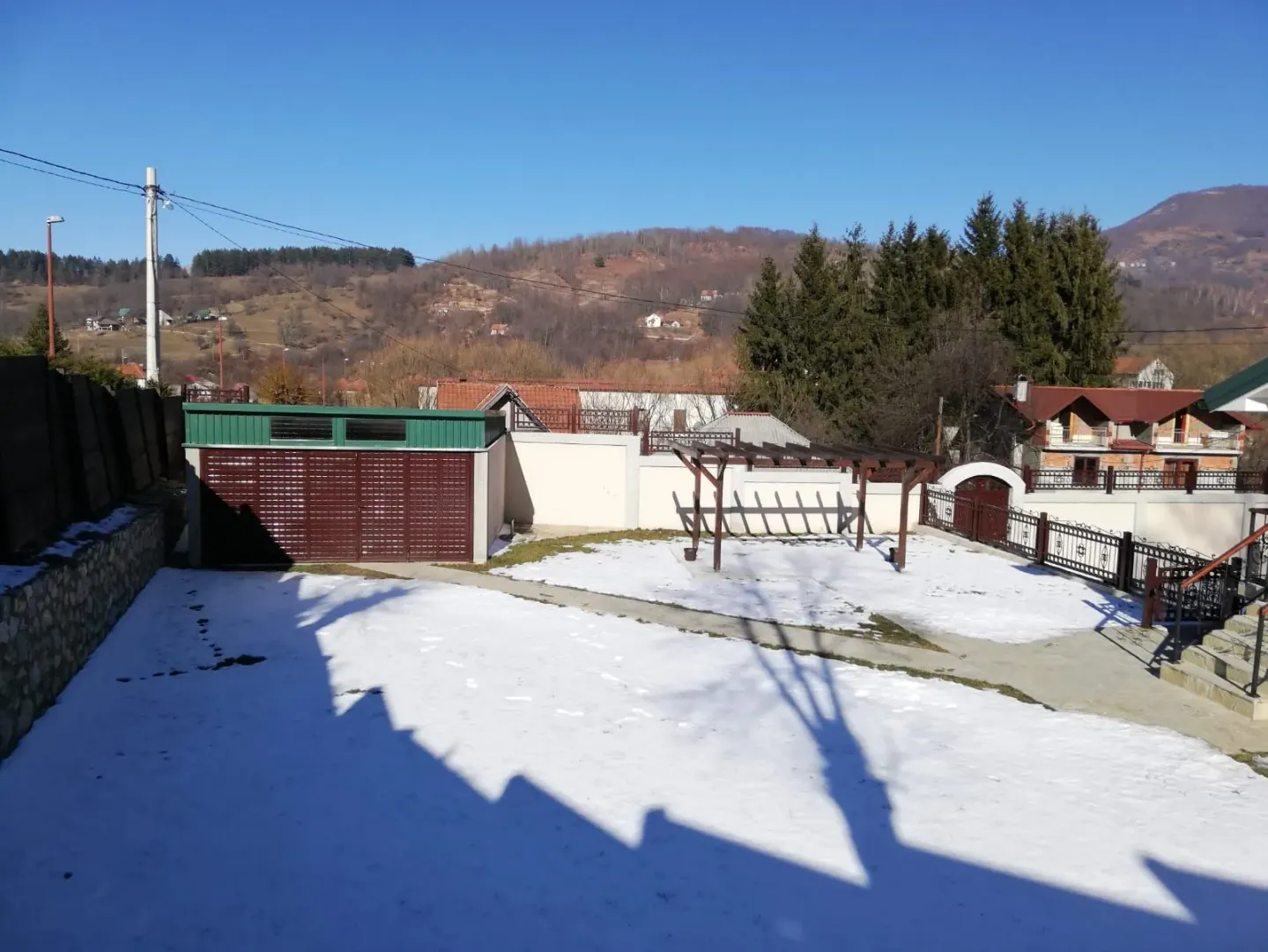 Pogled na dvorište i okolinu prekrivene snijegom.